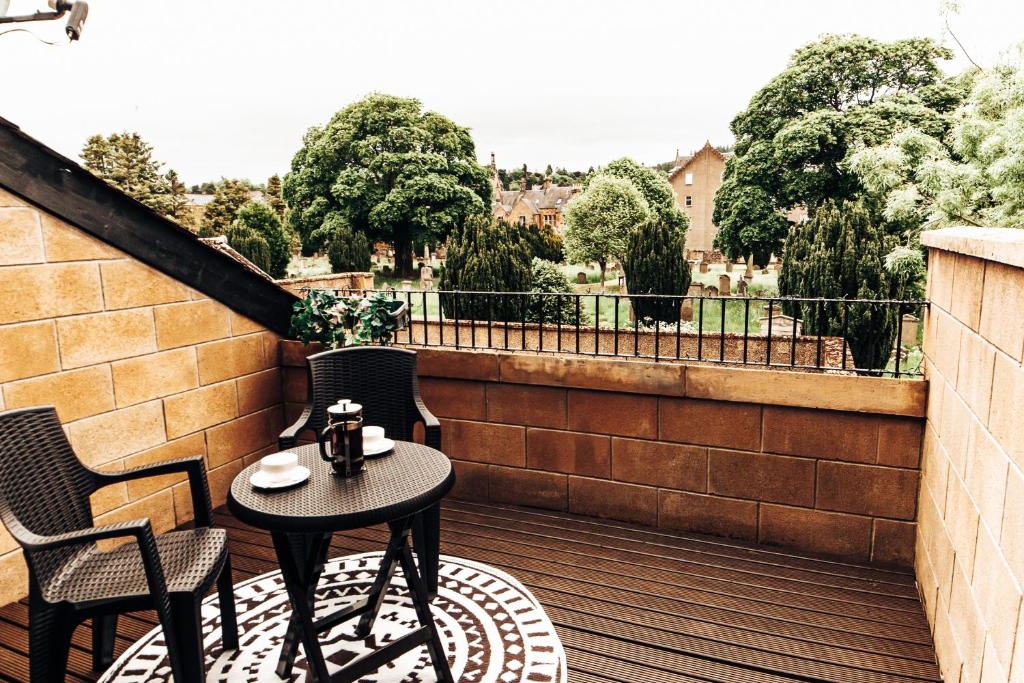 een patio met een tafel en stoelen op een balkon bij Princes Street Apartment in Perth