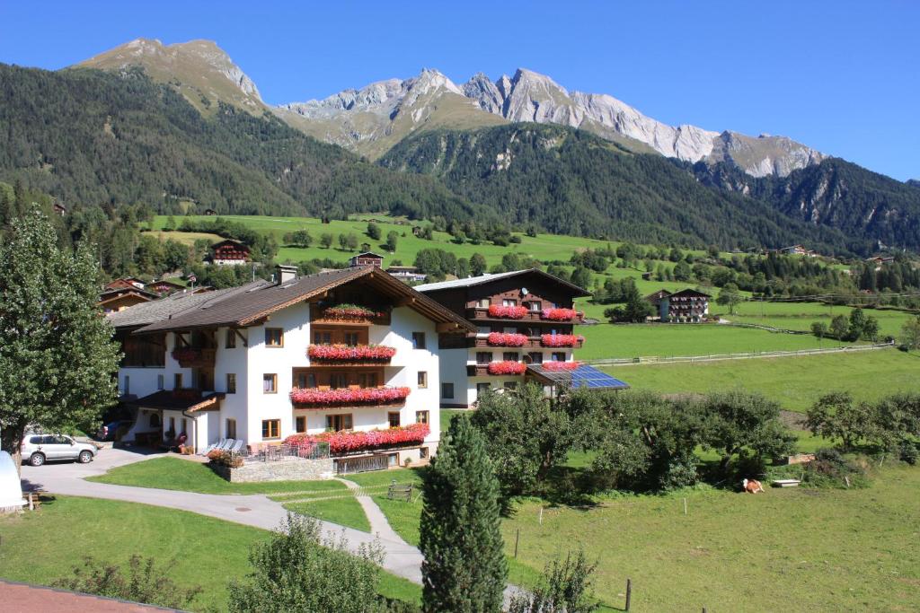 Ein Gebäude auf einem Feld mit Bergen im Hintergrund in der Unterkunft Habererhof in Virgen