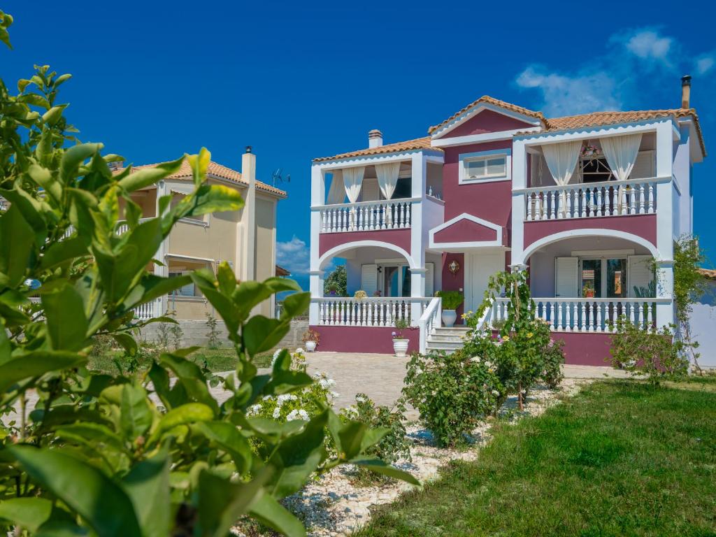uma casa rosa e branca com um quintal em Villa Zakynthian treasure em Vanáton