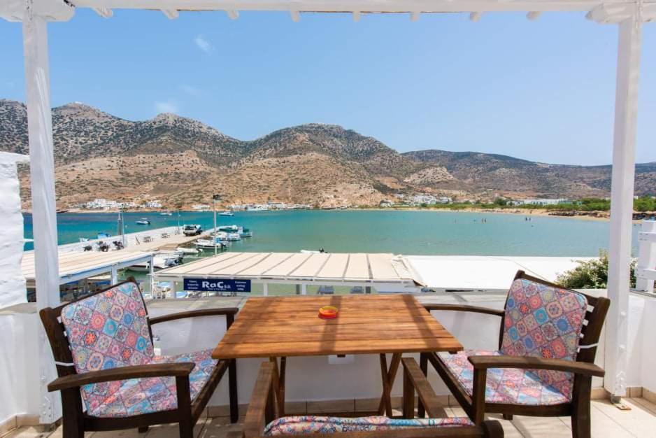 una mesa y sillas en un balcón con vistas al agua en Almyra seaside house, en Kamarai