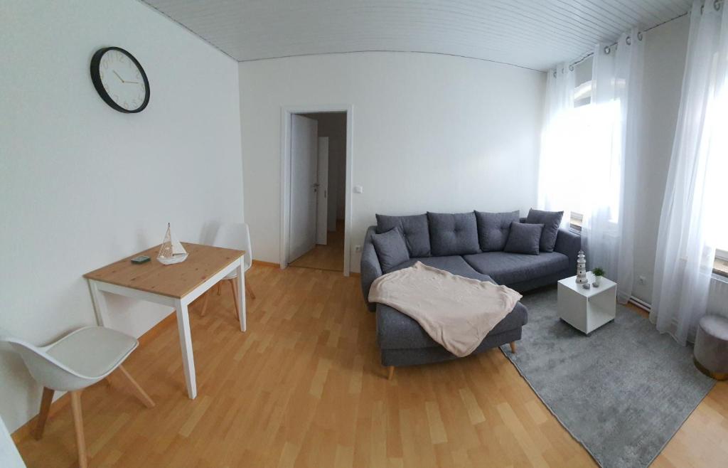 een woonkamer met een blauwe bank en een tafel bij Ferienwohnung Preveza in Kappeln