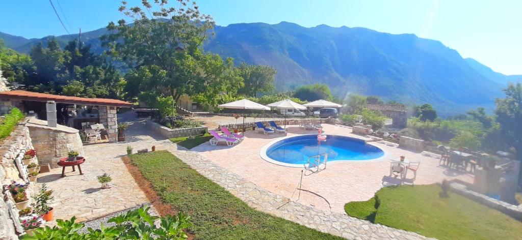um resort com piscina e montanhas ao fundo em Vila Pegaz em Virpazar