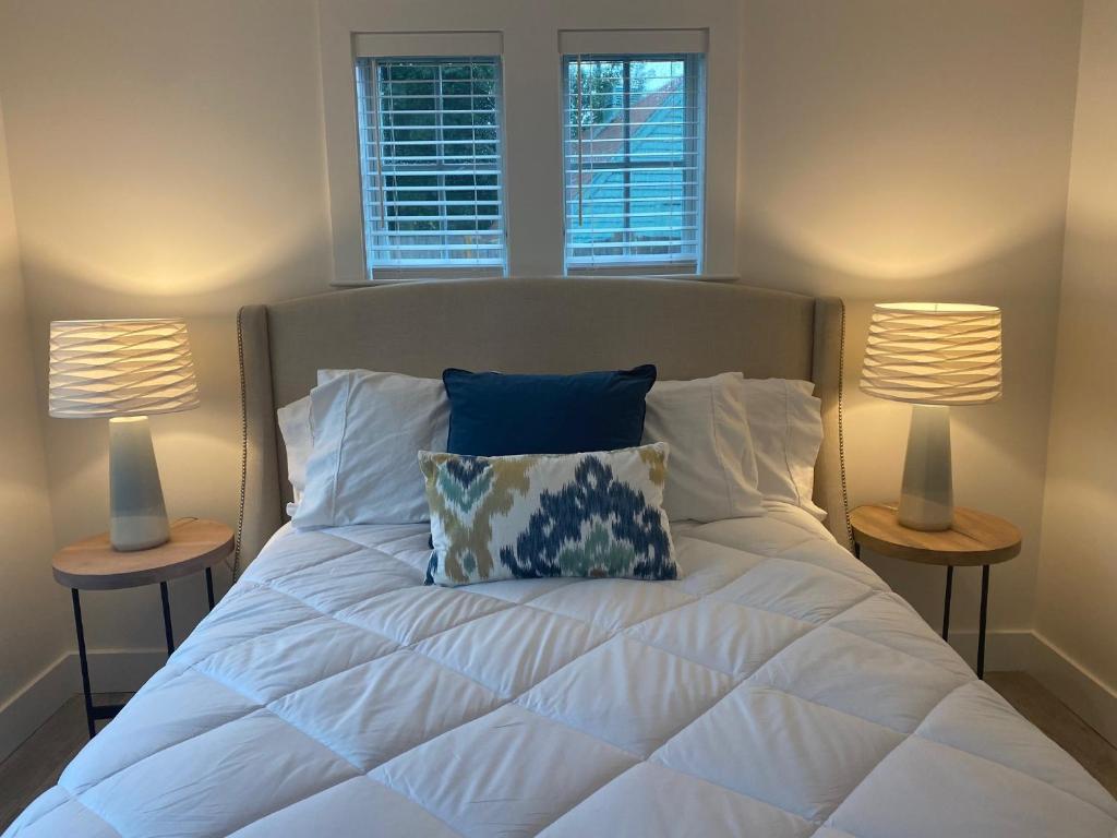 a bedroom with a white bed with two lamps at Harbourtown Suites in Plymouth
