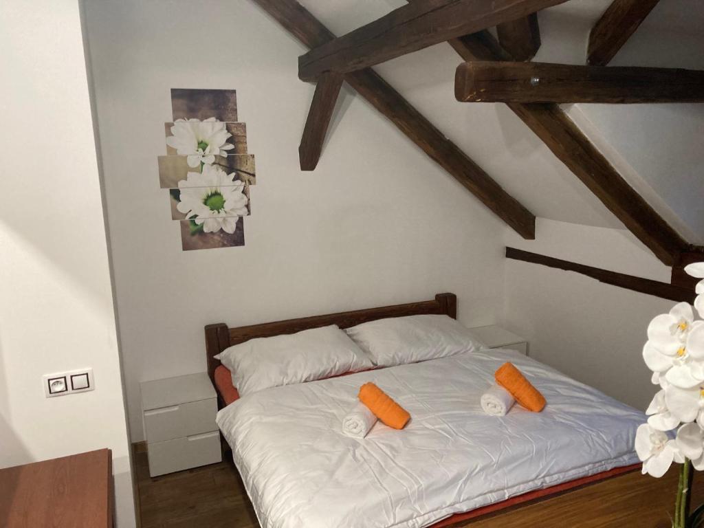 Apartmánový dům 13 Podkroví 2 في سيتش: غرفة نوم مع سرير أبيض ومخدات برتقالية عليه
