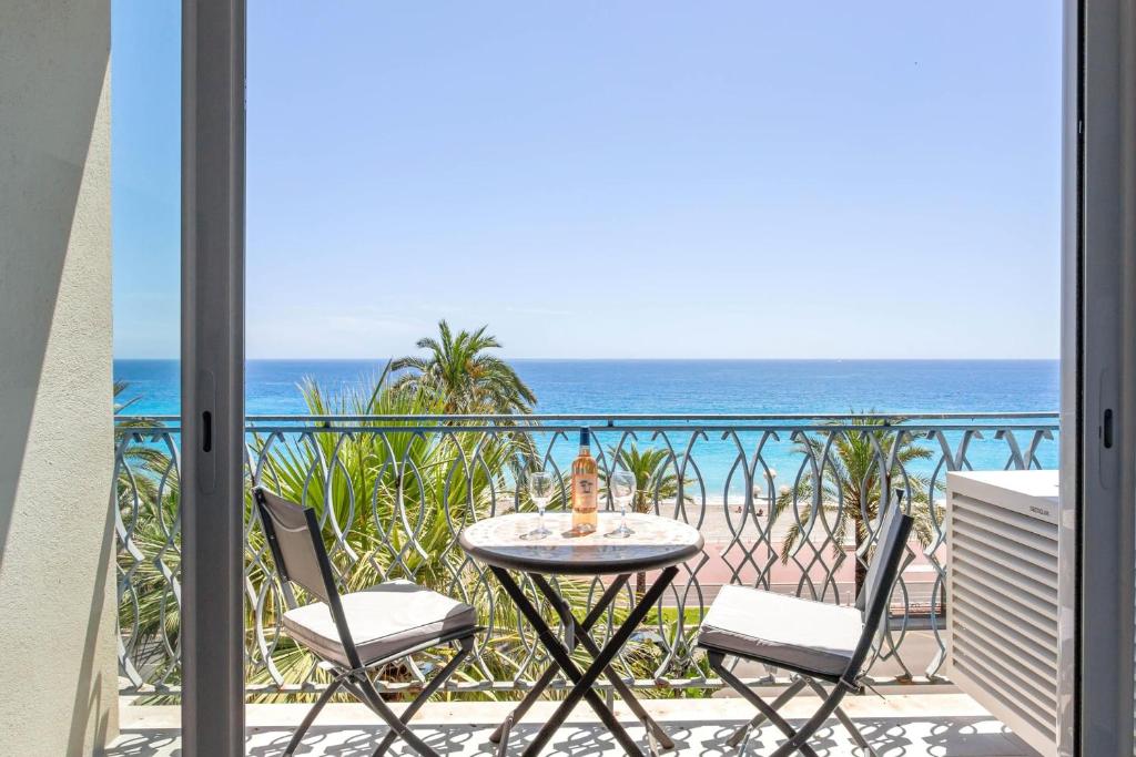 a balcony with a table and chairs and the ocean at Studio du Grand Sud - Welkeys in Nice