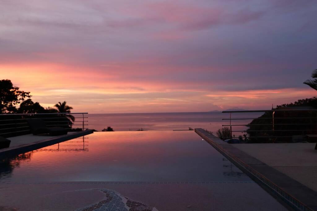 a swimming pool with a sunset in the background at The Boathouse Villa in Salad Beach