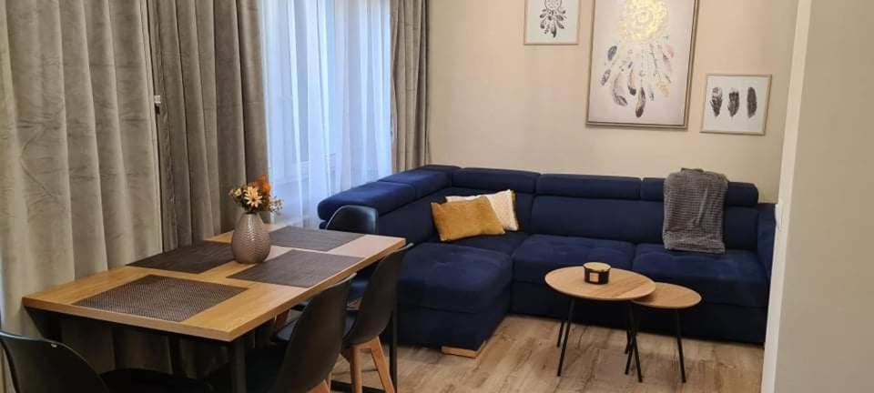 a living room with a blue couch and a table at Karpacz Apartament Chabrowy in Karpacz