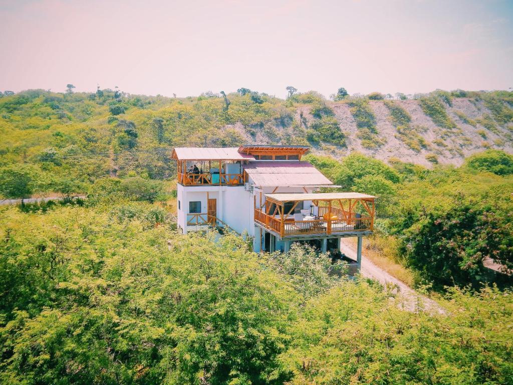 a house on the side of a hill with trees at Hermanos Perdidos Surf in Las Tunas