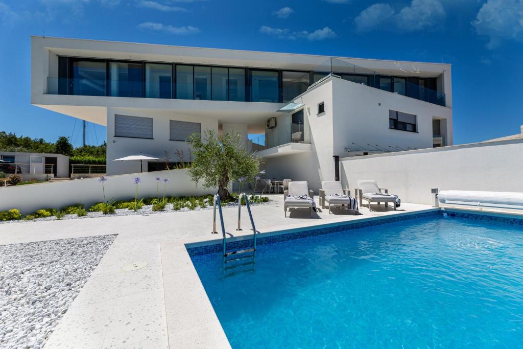 a house with a swimming pool in front of a house at Villa Bianca in Vantačići