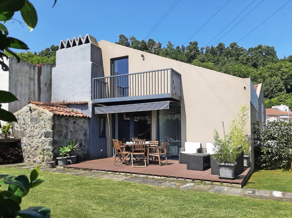 a house with a patio with a table and chairs at Furnas Valley in Furnas