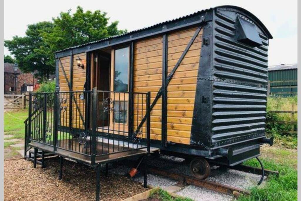 a tiny house sitting on display in a yard at Malthouse Farm Cottage Carriage in Dilhorne