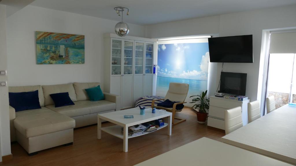 a living room with a couch and a tv at Piso en Santa Cristina, a 150 m de la playa in Oleiros