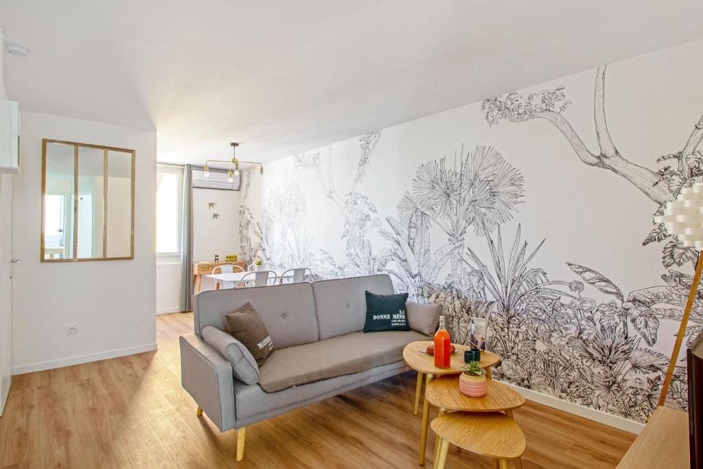 a living room with a couch and a wall mural at Beautiful flat with balcony in the heart of Marseille - Welkeys in Marseille