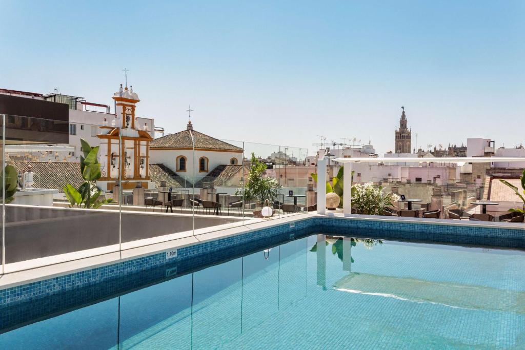 a swimming pool with a large swimming pool in front of a building at Radisson Collection Hotel, Magdalena Plaza Sevilla in Seville