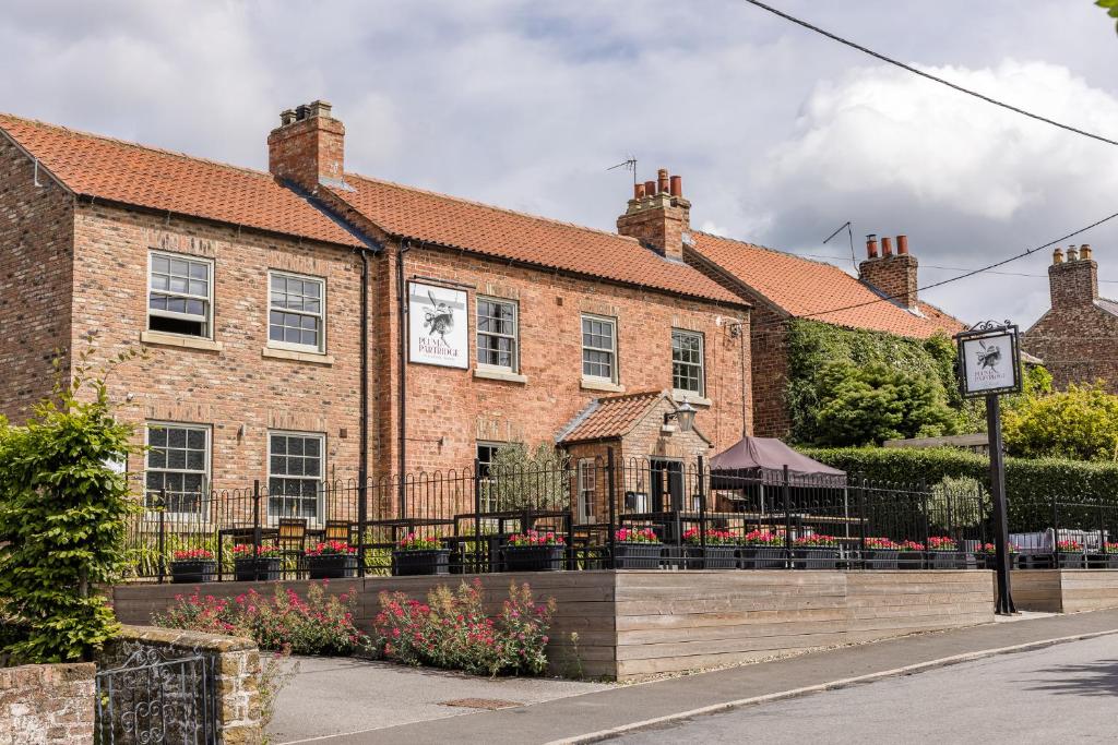 ein Backsteingebäude mit einem Restaurant davor in der Unterkunft Plum and Partridge Husthwaite in York