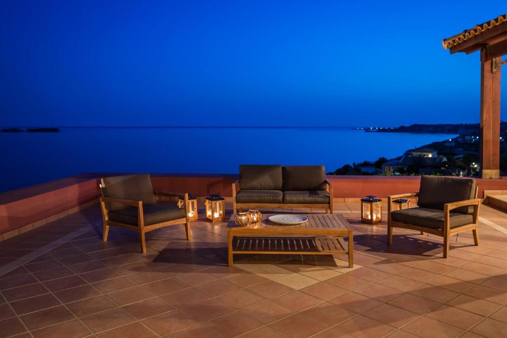 een woonkamer met 2 stoelen en een salontafel bij Alekos Beach Houses-Eternity in Xi