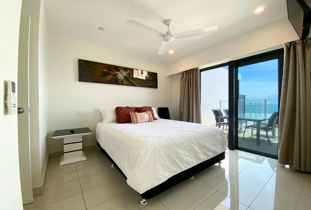 a bedroom with a bed and a view of the ocean at “PENZANCE” Great Location & Views at PenthousePads in Darwin