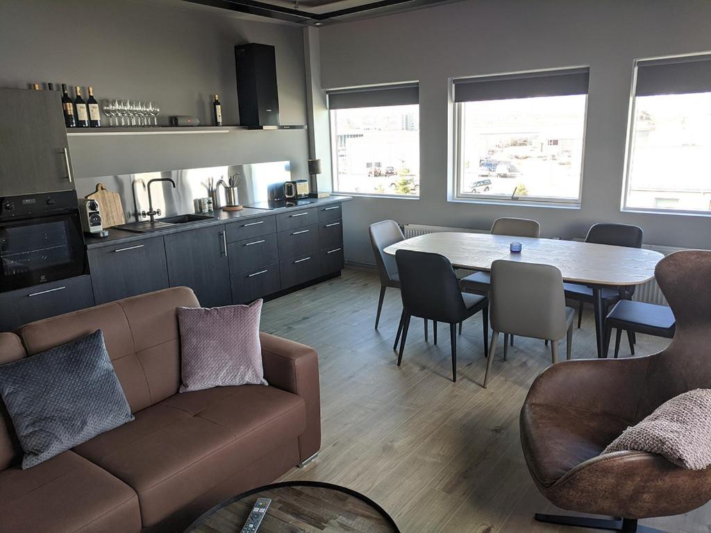 uma sala de estar com um sofá, uma mesa e cadeiras em Boutique by the harbour - Apartments 207 Akureyri em Akureyri