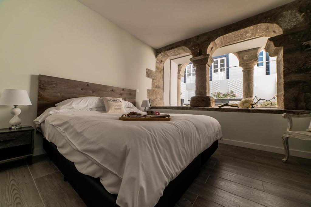 una camera con un grande letto con testiera in legno di Ocean - Casa Sao Joao - 4 Star Tourist Apartments ad Angra do Heroísmo
