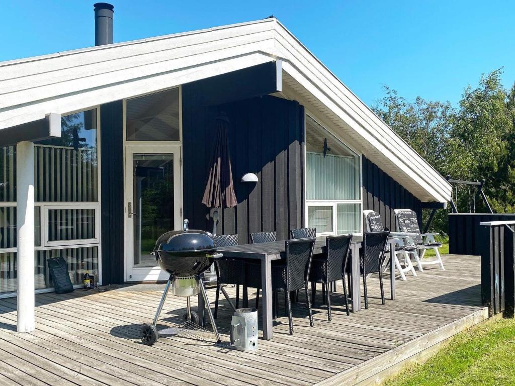 a grill on a deck next to a house at 6 person holiday home in Jerup in Jerup
