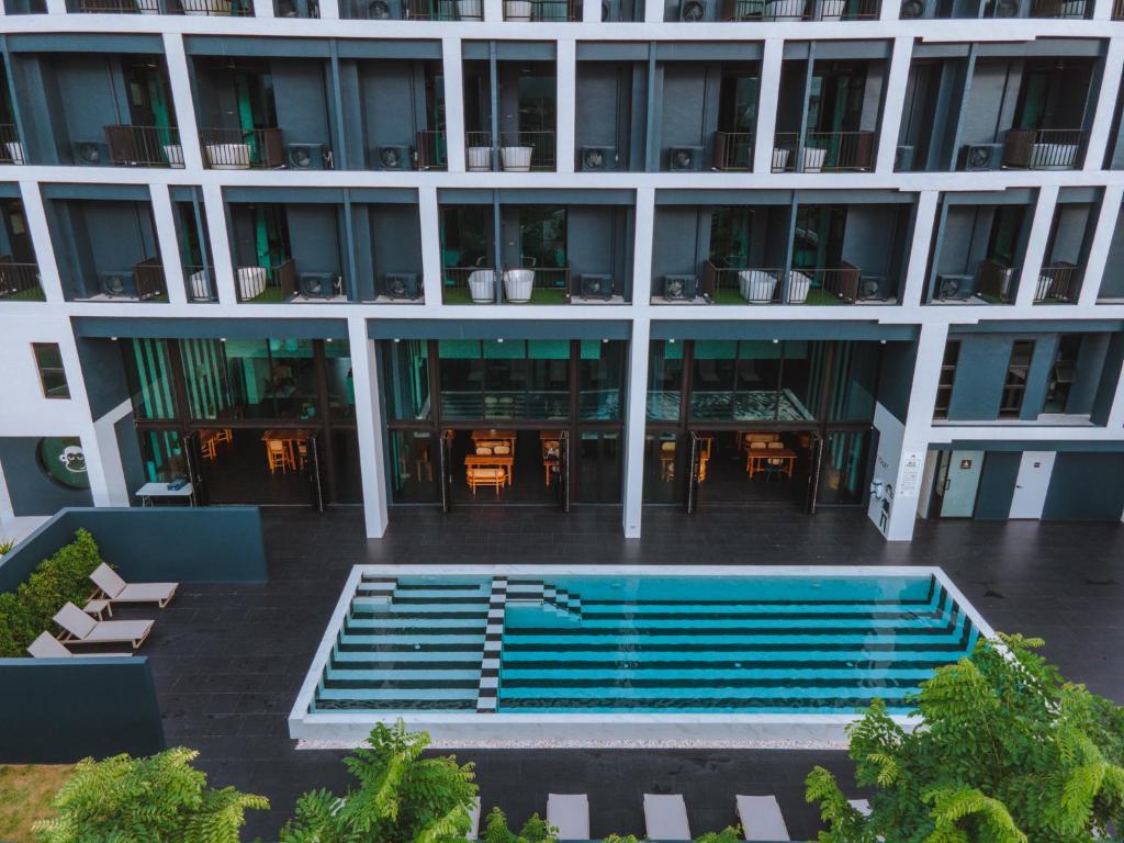 a large building with a swimming pool in front of it at Blu Monkey Hub and Hotel Chanthaburi in Chanthaburi