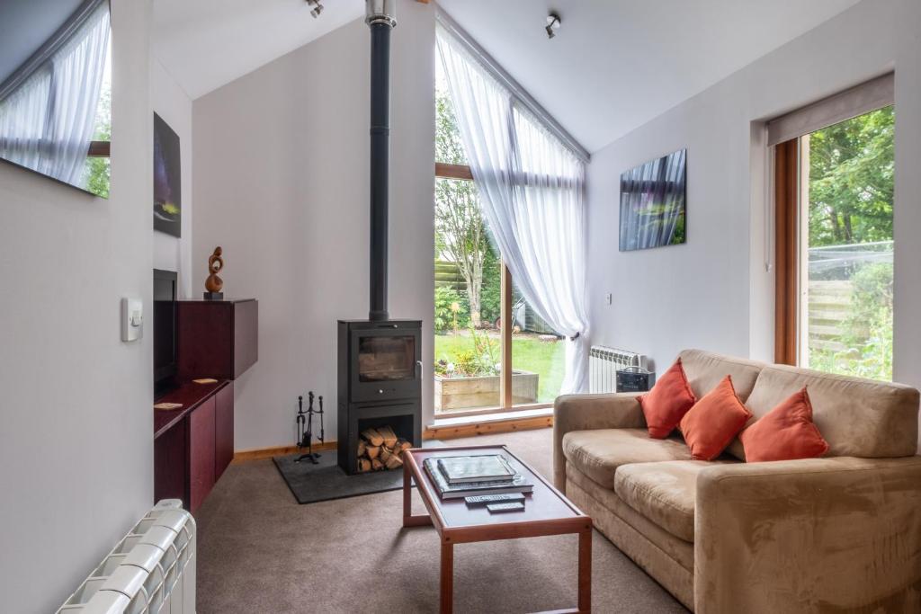 a living room with a couch and a fireplace at Contemporary One Bedroom Apartment Close To All Amenities In Conservation Area in Tain