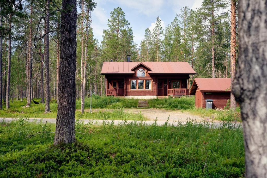a cabin in the woods with a red roof at Viihtyisä lomamökki Levillä in Sirkka