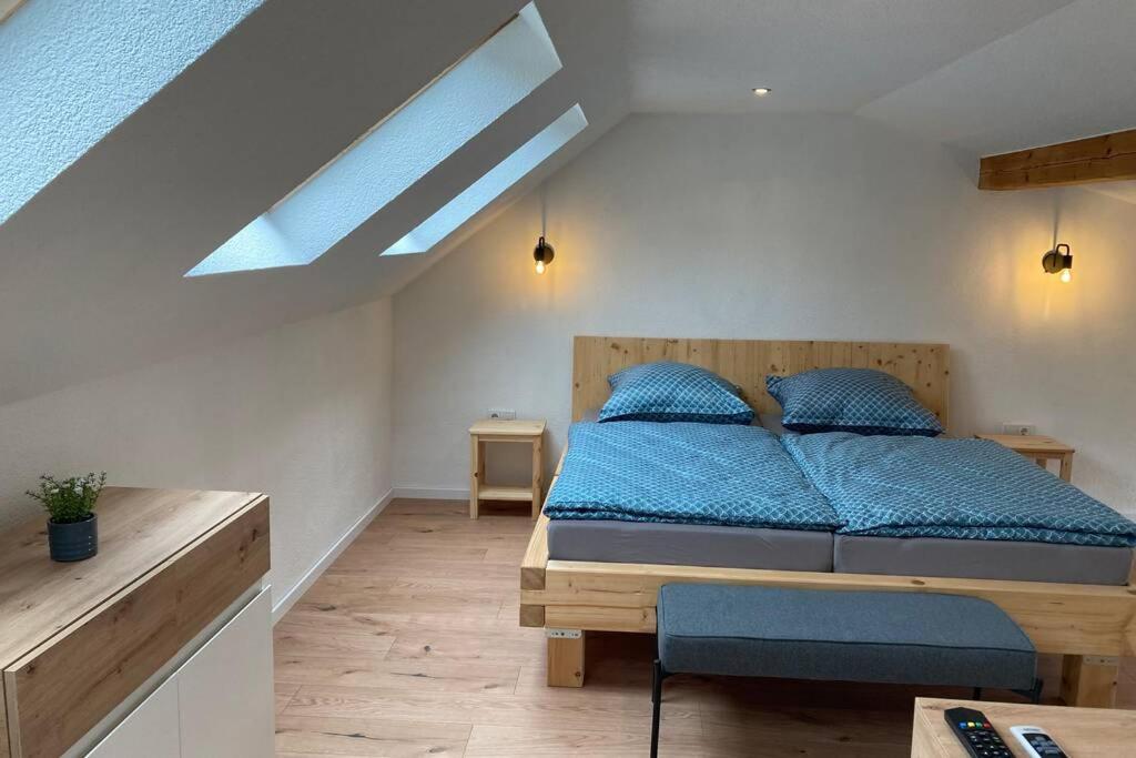 a bedroom with a bed with blue sheets and a skylight at Ferienwohnung zum Mandelgraben in Brauneberg
