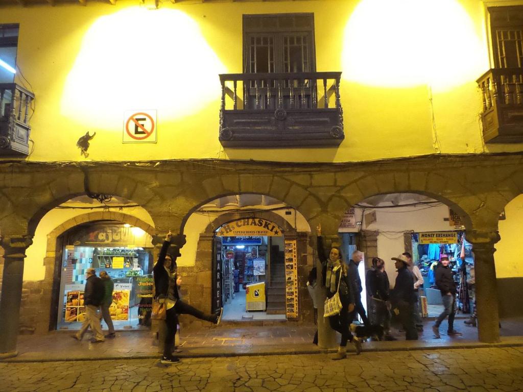 a group of people walking down a street at night at Hostal Chasky in Cusco