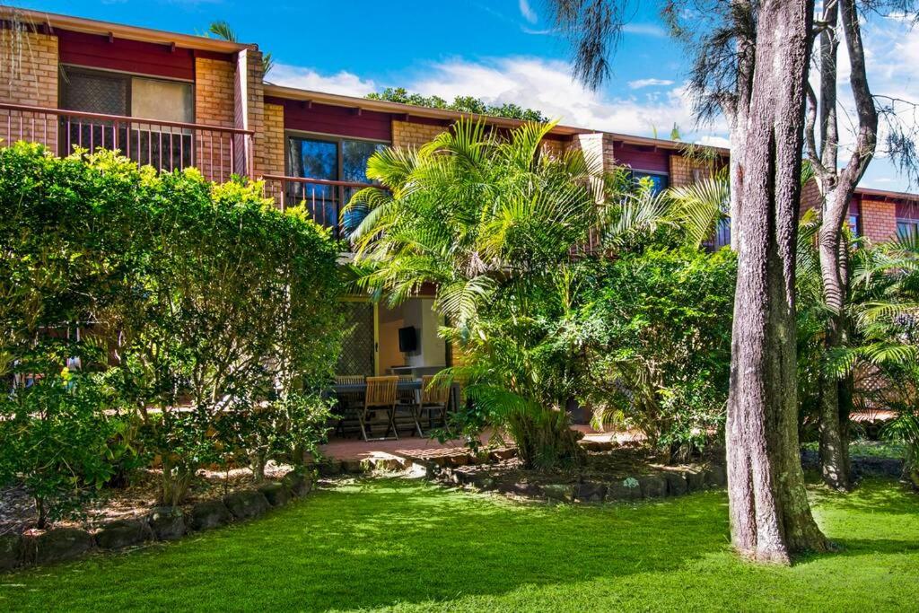 una casa con palmeras frente a un patio en Byron Bay Accom - Kipling 6 - 6/15 Kipling St, en Byron Bay