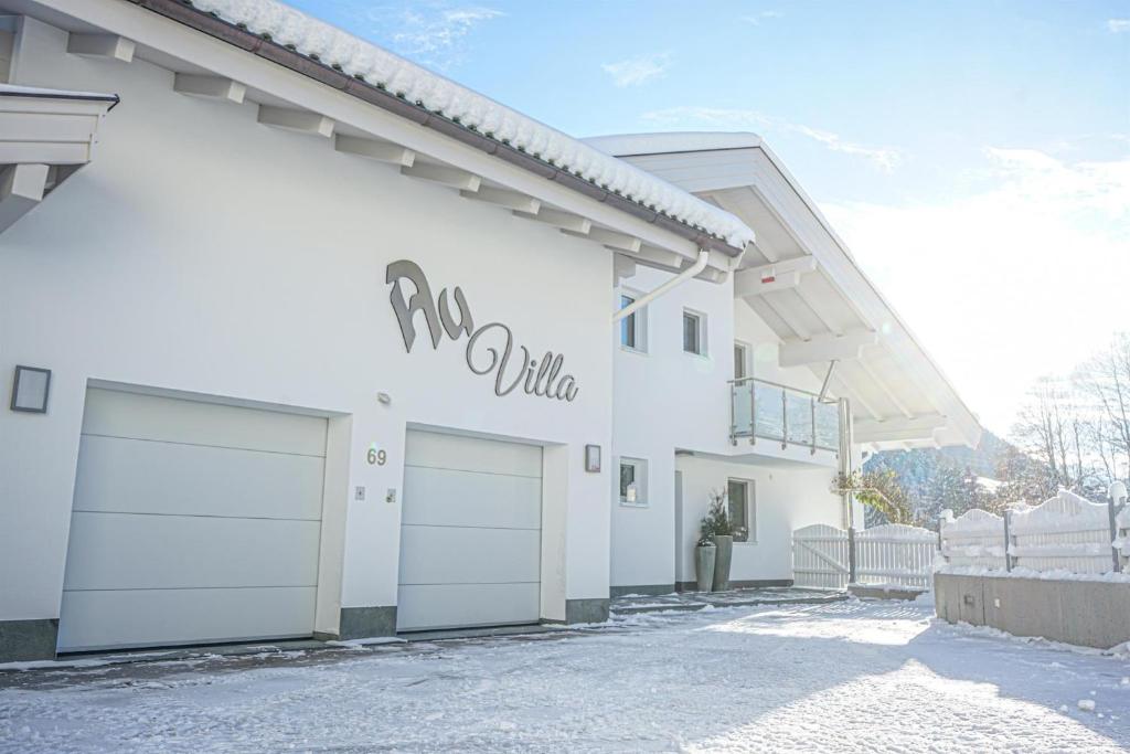 a white building with two garage doors on it at Au Villa in Söll