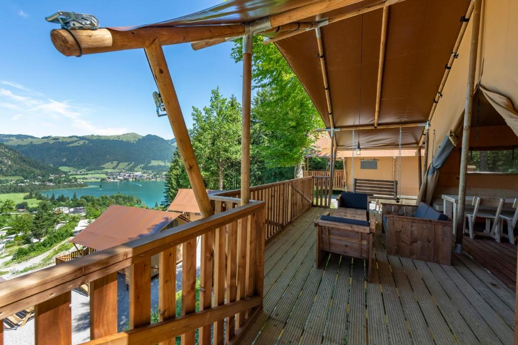 a deck with a view of a river and mountains at Ferienpark Terrassencamping Süd-See in Walchsee