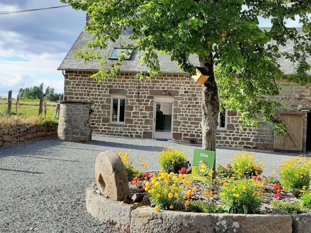 ein Steingebäude mit einem Blumengarten davor in der Unterkunft Gîte Saint-Fraimbault, 4 pièces, 7 personnes - FR-1-497-74 in Saint-Fraimbault-sur-Pisse