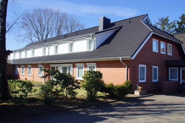 a large red brick house with a black roof at Heidhof in Bispingen