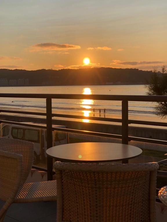 um pôr-do-sol num navio de cruzeiro com uma mesa e cadeiras em Hôtel Valencia em Hendaye