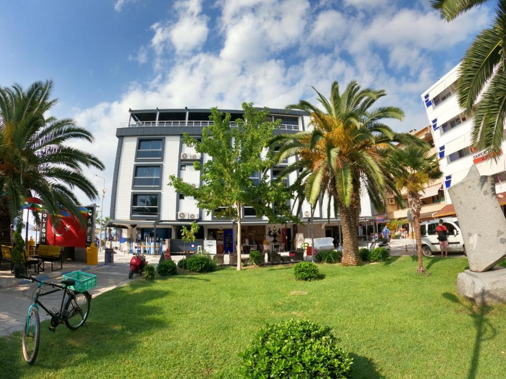 a bike parked in front of a building with palm trees at avsa extra vagant hotel in Avşa Adası