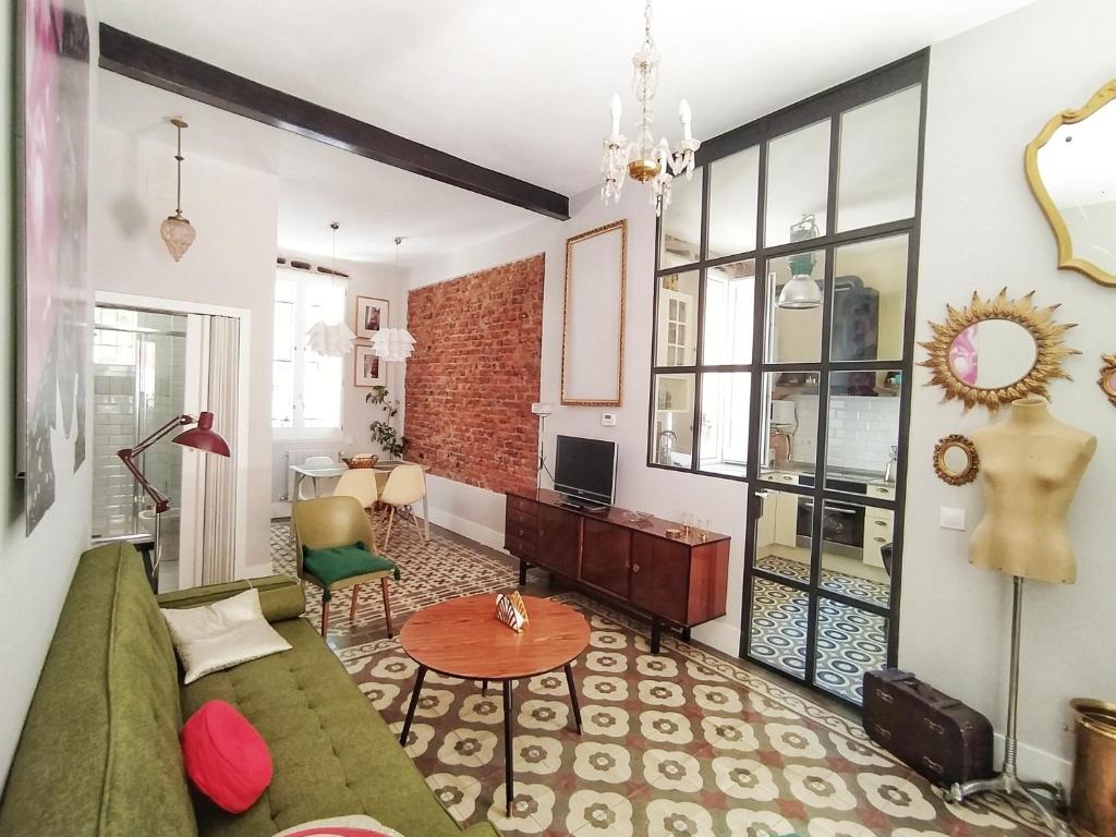 uma sala de estar com um sofá verde e uma mesa em La Casita Vintage em Madrid