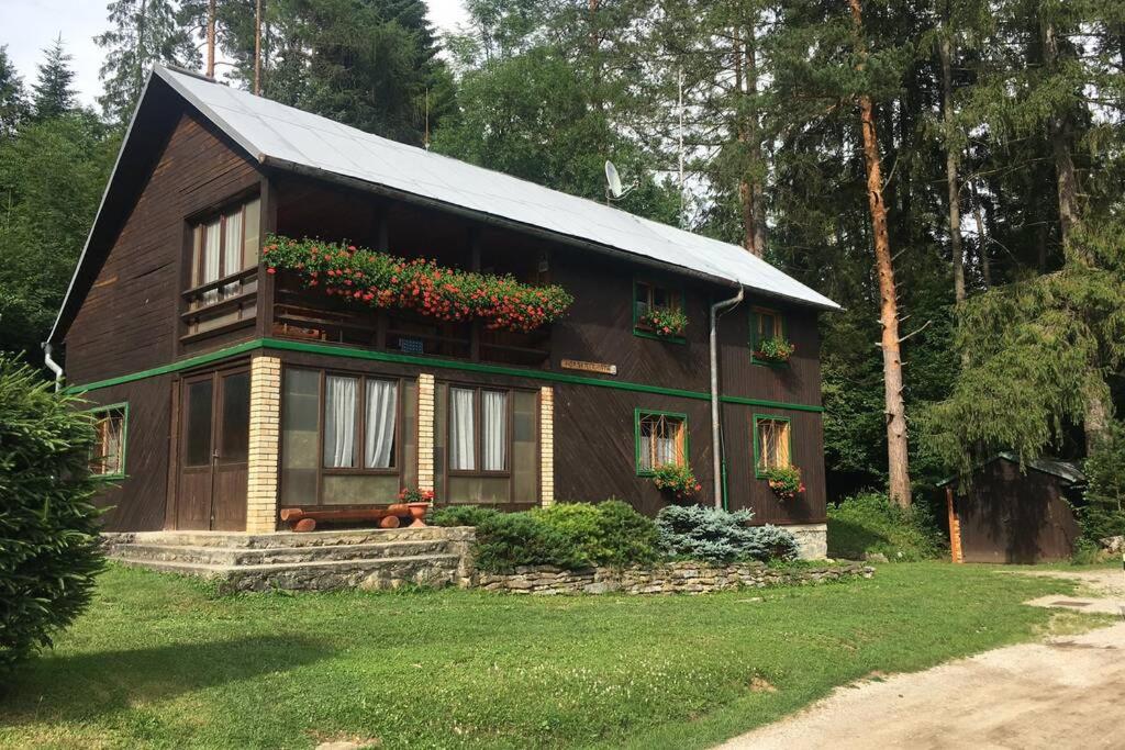 a small house with flowers on the balcony at Horská chata v Slovenskom raji in Spišské Tomášovce