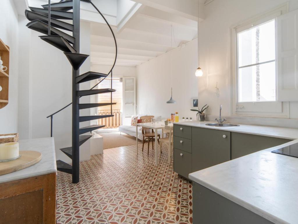 a kitchen with a spiral staircase in the middle of a room at White penthouse in Barcelona