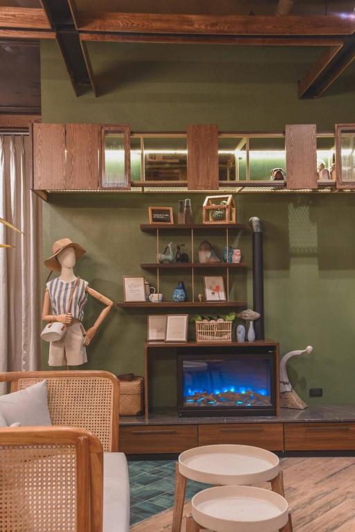 A styled lounge corner with a television, display shelves and a mannequin.