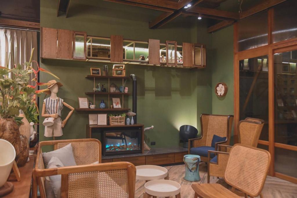 A relaxed lounge with cane chairs, small tables, bookshelves and a decorative fireplace.