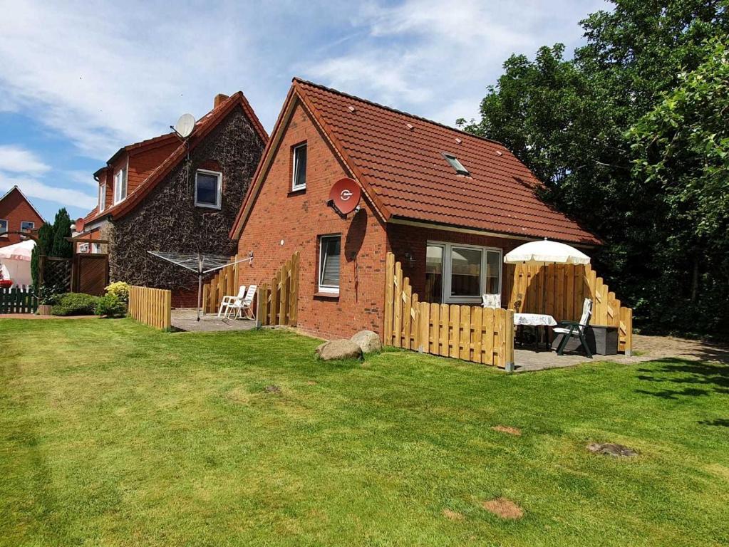 a house with a dog in front of a yard at Ferienhaus Dollartbrise 45005 in Pogum