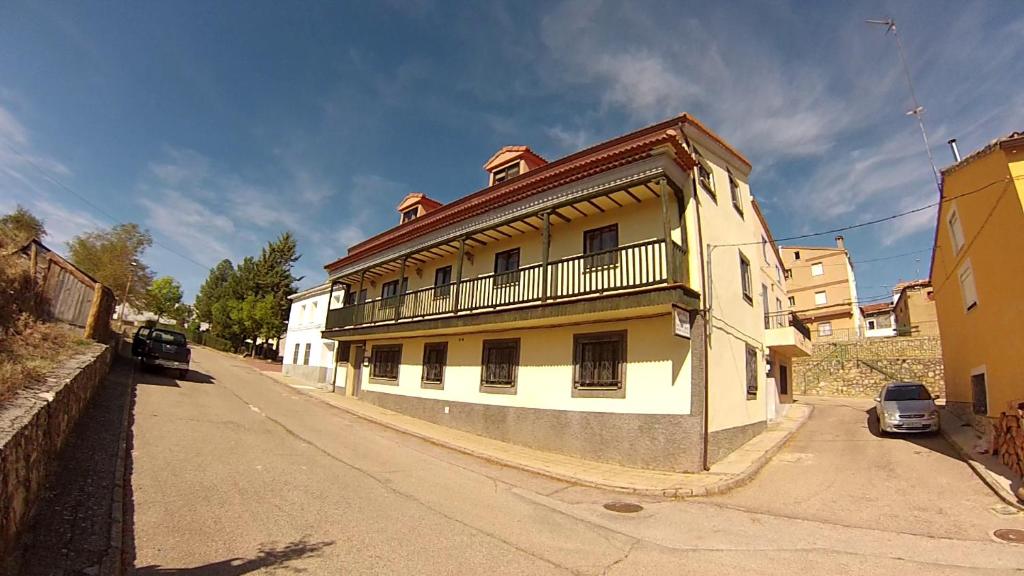 a white building with a balcony on a street at Apartamento EL BALCON in Cuenca