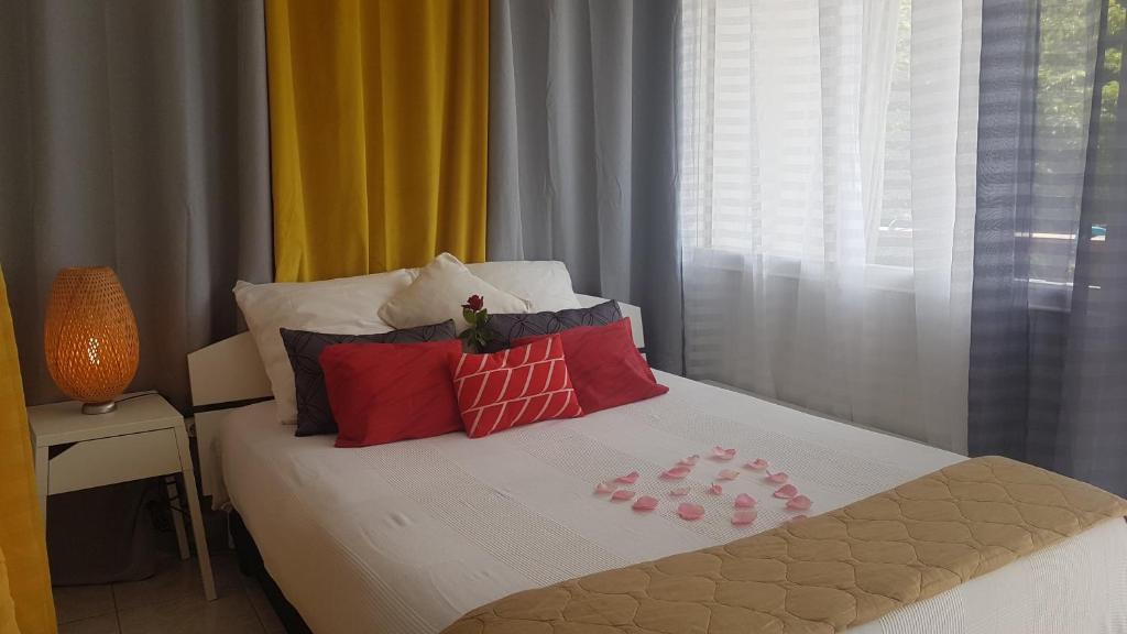 ミミザンにあるLa Pinède Océane,400m des plagesのベッドルーム1室(赤い枕のベッド1台、窓付)