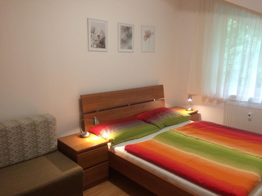 - une chambre avec 2 lits et des draps colorés dans l'établissement Apartment Safran, à Donovaly