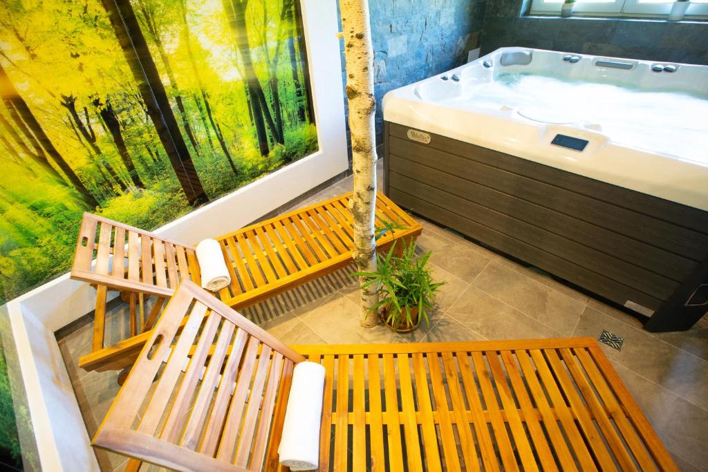 Two wooden loungers with rolled towels next to bubbling hot tub and vibrant mural.