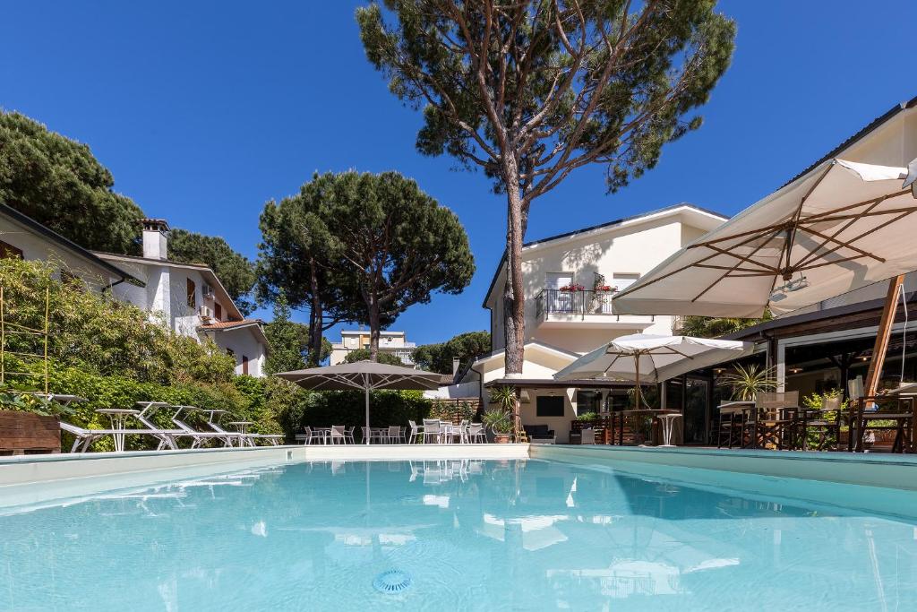 a swimming pool with umbrellas and a building at La Tavernetta in Marina Romea