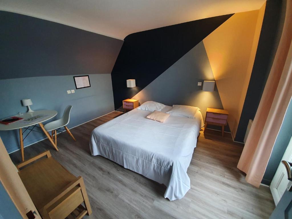 a bedroom with a white bed and a table and a desk at Le Flobart in Le Portel
