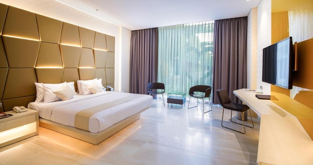 FM7 Resort Hotel - Jakarta Airport في تانغيرانغ: غرفه فندقيه سرير وتلفزيون