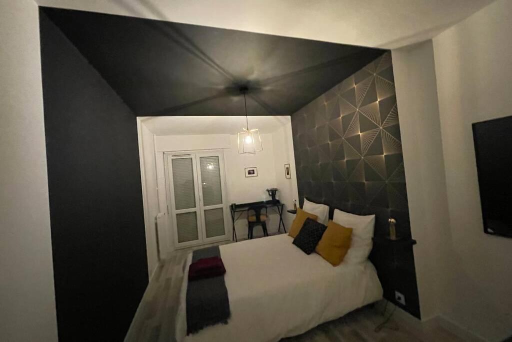 a bedroom with a large bed with a black headboard at Les Demeures Lady DY in Saint-André-les-Vergers